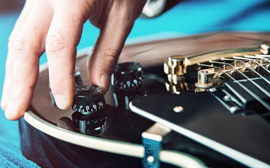 Hand fixing volume on guitar