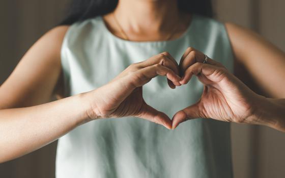 Close up of woman making heart shape with hands