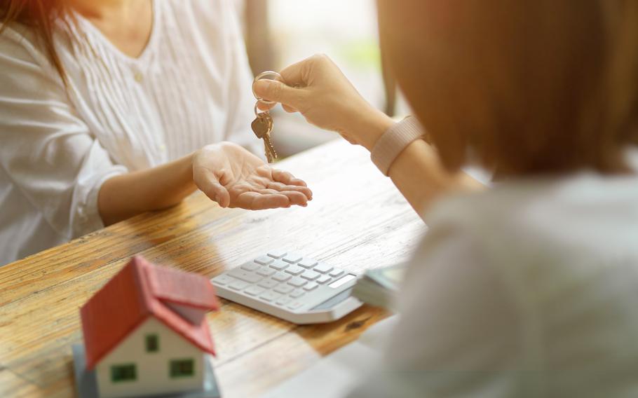 Person receives a house keys chain from a real estate broker.
