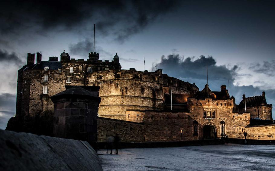 An view of Edinburgh Castle, its towering stone walls illuminated under a brooding sky, creating a sense of grandeur and mystery.