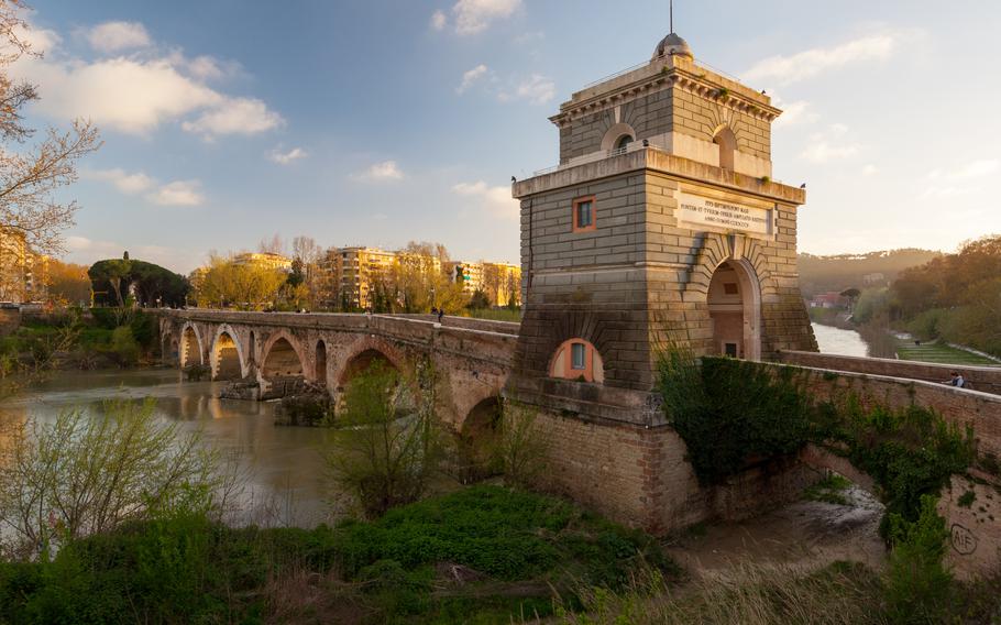 This picturesque photo captures the iconic Ponte Milvio, one of the oldest bridges in Rome, Italy. Spanning the Tiber River, the bridge is renowned for its historic significance and as a romantic spot where couples attach love locks to its lampposts. The stunning stone architecture, complemented by lush greenery and a backdrop of modern buildings, highlights the harmonious blend of ancient history and contemporary life. A must-visit for history enthusiasts and romantics, Ponte Milvio offers a serene escape and a glimpse into Rome’s timeless charm.