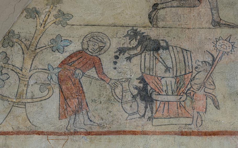 Frescho of a monk pouring beer from a barrel, east wall, Orslev church, Denmark