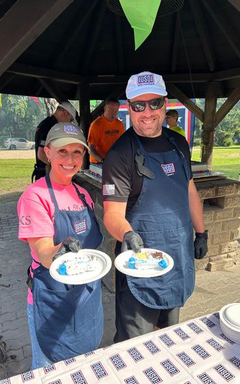 USO volunteers offering slices of cake to the camera