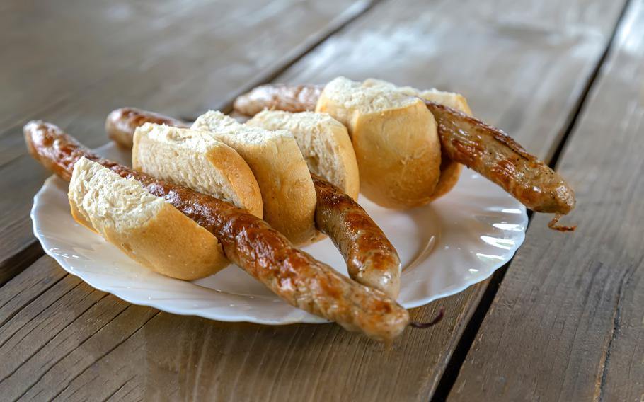 national traditional grilled thuringian sausages in buns on a plate on a wooden table