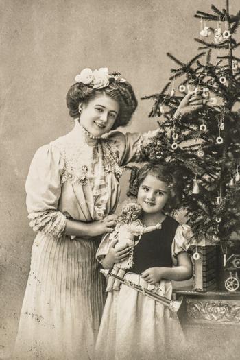 Woman and child with christmas tree and antique toys. Vintage sepia picture-style.