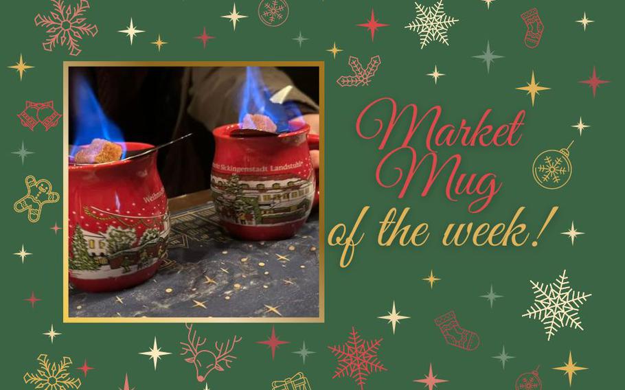 An up-close photo of two red Christmas market mugs with snowy villages painted on them and a flaming sugar cube resting on top of each mug. 