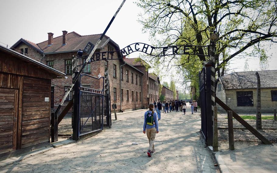 This powerful image captures the entrance gate to Auschwitz I, the former Nazi concentration and extermination camp in Oświęcim, Poland. The infamous “Arbeit Macht Frei” sign, meaning “Work Sets You Free,” stands as a stark reminder of the atrocities committed during World War II. Framed by the historic brick buildings and barbed wire fences, this solemn site serves as a crucial symbol for honoring the memory of the millions of victims and reflecting on the importance of preserving history to ensure it is never forgotten.