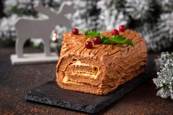 The Bûche De Noël, or Yule Log, is a stunning traditional chocolate dessert that embodies the festive spirit of the holiday season. Crafted to resemble a log, this decadent treat features a rich sponge cake rolled with luscious chocolate buttercream and dusted with powdered sugar to mimic fresh snow. Adorned with intricate decorations like edible holly, berries, and meringue mushrooms, it’s as beautiful as it is delicious. Set against a festive background with twinkling lights and seasonal accents, the Bûche De Noël is a timeless centerpiece that brings joy and elegance to any holiday celebration.