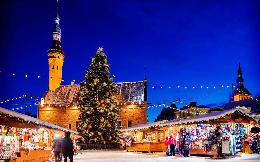 Tallinn Christmas Market in Market Square with a festive Christmas tree, twinkling lights, and charming medieval architecture.