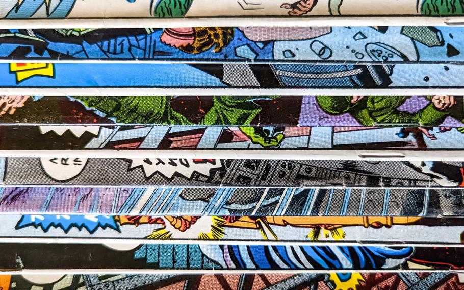 Vintage comic book collection stacked in a pile creates a background pattern of colorful lines and shapes on old paper