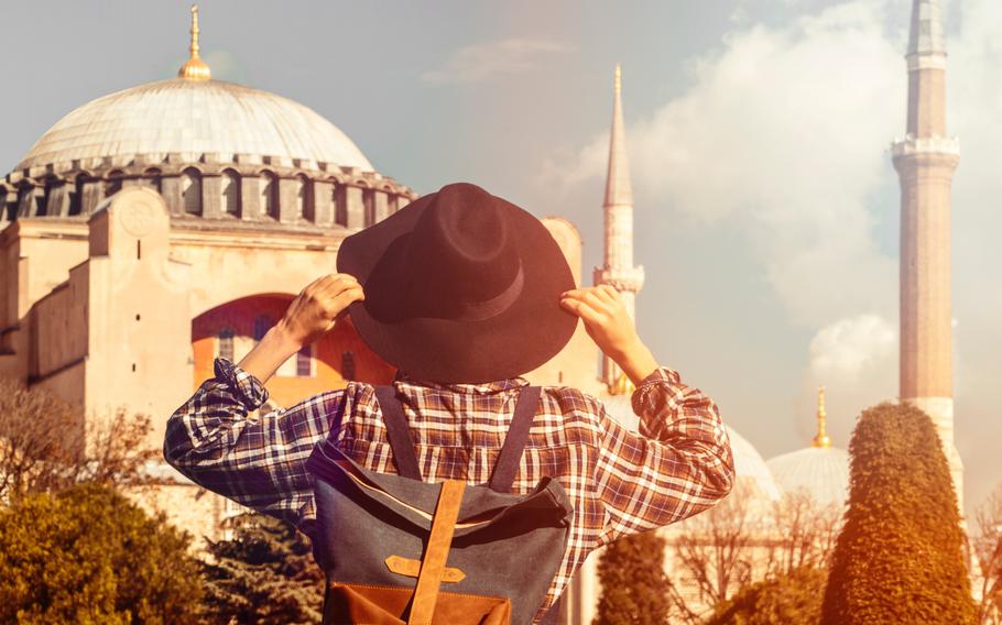 Person holding hat looking away from camera in Instanbul