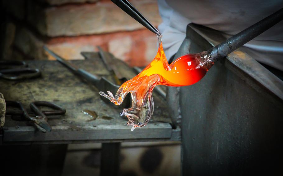 Glass Artist in her workshop making glassware in the shape of a horse 