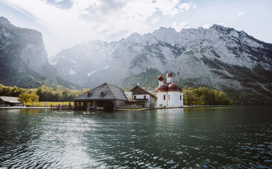 Classic panoramic view of Lake Konigssee with world famous Sankt Bartholomae pilgrimage church and Watzmann mountain in beautiful golden evening light at sunset in summer, Berchtesgadener Land, Bavaria, Germany