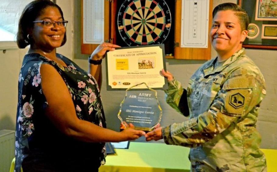 U.S. Army Garrison Wiesbaden Army Emergency Relief Officer Briana Johnson (left) recognizes Staff Sgt. Monique Garcia of Headquarters and Headquarters Detachment, 24th Military Intelligence Battalion, for her exemplary efforts during the 2023 AER Campaign. 