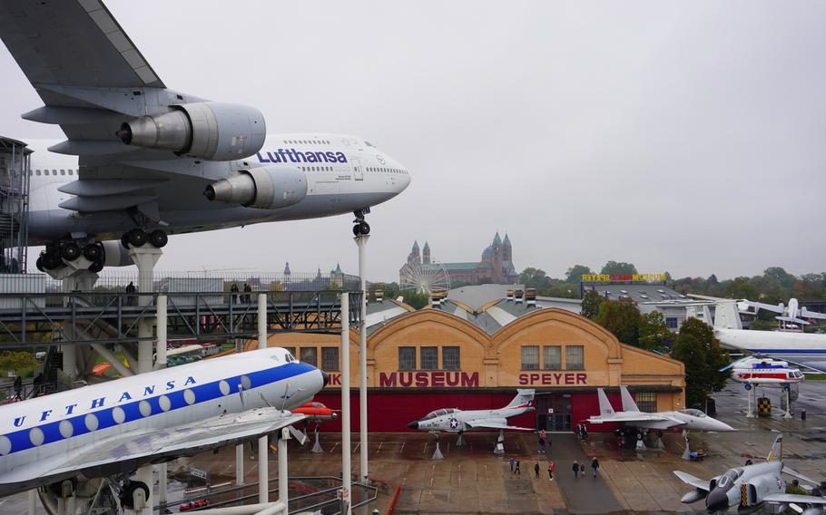 The Technik Museum in Speyer, Germany, features an impressive outdoor display of aviation history, including a towering Lufthansa Boeing 747 and other iconic aircraft. The museum’s brick façade is complemented by a backdrop of the Speyer Cathedral and a nearby Ferris wheel, creating a unique blend of culture and technology. Visitors can explore the exhibits and marvel at the engineering achievements showcased in this dynamic setting.                        