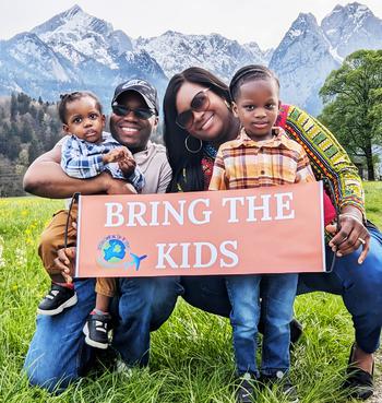 Simone Atkinson and her family holding a sign that says “Bring the Kids”