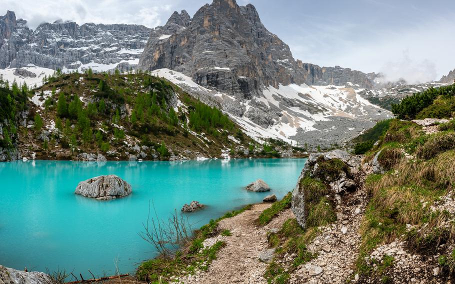 Panoramic view of Lago Sorapis in the Dolomites (Dolomiti, Dolomiten), Italy. The turquoise lake is surrounded by towering cliffs and mountains, a popular spot for hikers and nature lovers