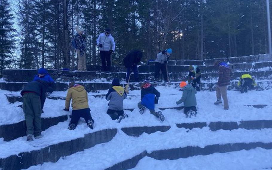 Members of Troop 44 mining for snow in the open-air theater that is part of the scout center.