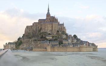 Mont-Saint-Michel at sunset pastel twilight sand low tide soft light perspective walkway