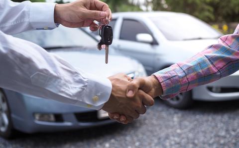 Photo Of The car salesman is handing over the keys to the buyer 