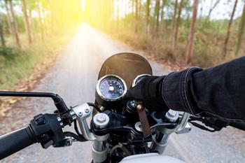 Close up of man’s hand on motorcycle handlebar. 