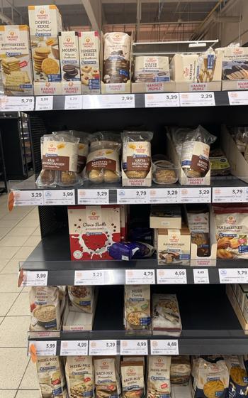 Shelves at a grocery store full of Hammermuhle gluten-free products in white and brown packaging. 