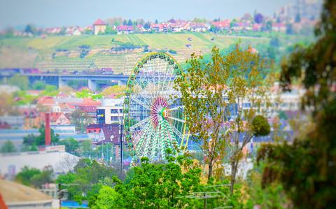 Photo Of a colorful picture of a german landscape with tress blossoming and a lime green Ferris wheel.