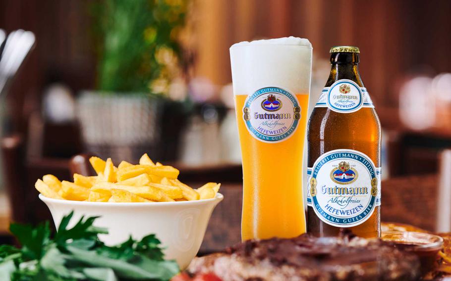 An assortment of food with a bottle of Hefeweizen bottle and glass.