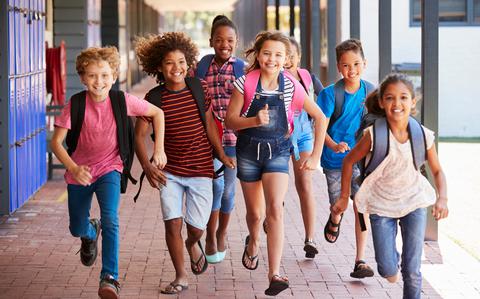 Photo Of Kids running by bright blue lockers on red brick