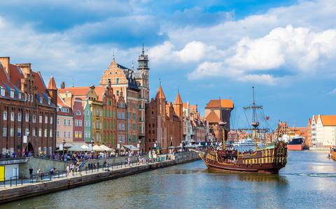 Photo Of Tourist ship and colourful historic houses reflection Motlawa river in port of Gdansk, Baltic Sea, Poland.