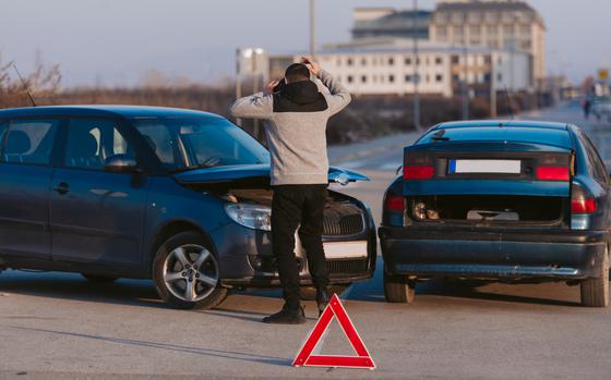 A guy is looking very angry after two cars crashing on the road