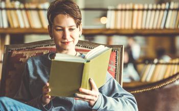 Woman reading a book in a chair.