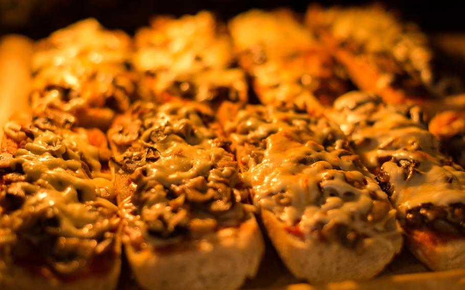 A typical oven-baked Polish zapiekanka (toasted baguette with white mushrooms and cheese) 