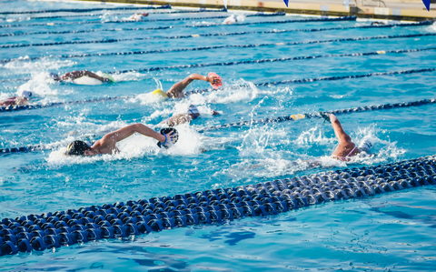 Photo Of Three swimmers, each in their own lane, swimming in a swim relay
