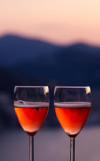 A couple of champagne glasses in front of mountains