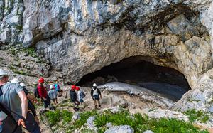 colorful picture of large group of people going into a cave 
