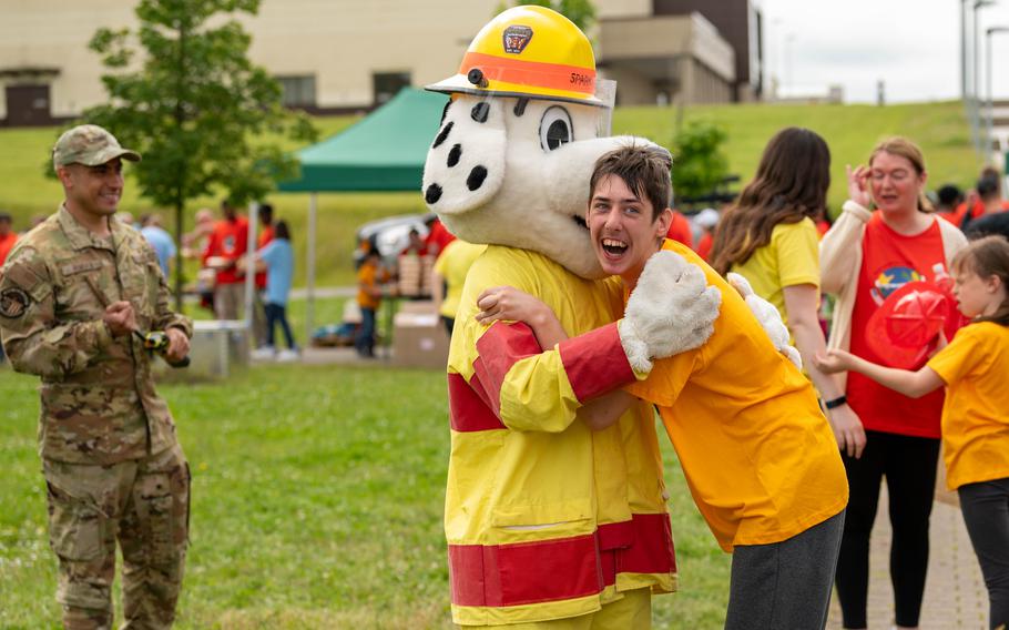 A participant in Spangdahlem Air Base’s 29th annual Special Children’s Day greets Sparky the fire safety dog at Spangdahlem AB, Germany, June 20, 2024. 