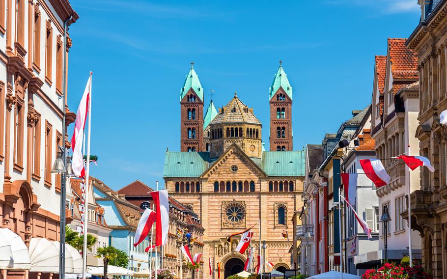 Maximilianstraße in Speyer offers a picturesque view of the majestic Speyer Cathedral, framed by vibrant historic buildings and festive flags. This bustling street, filled with shops and cafes, serves as the perfect gateway to the iconic Romanesque landmark.