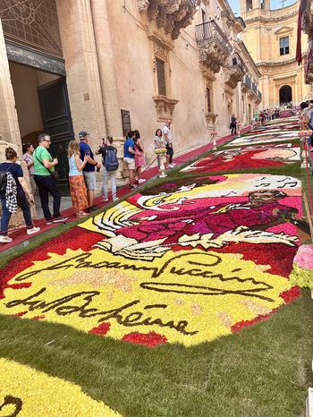 People standing to the left of painted grass art