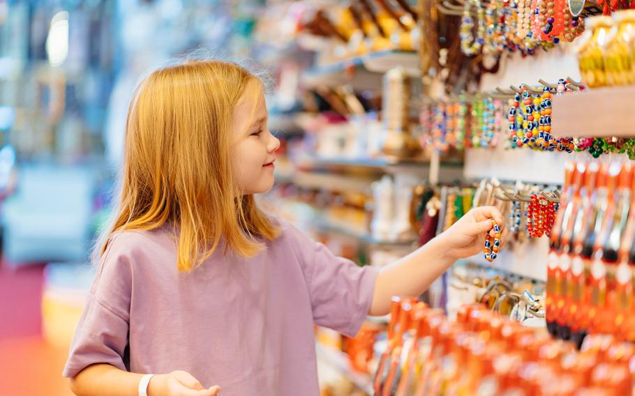 Girl looks at jewelry and souvenirs in the store. 