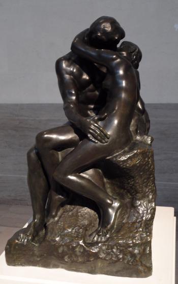 a bronze statue where two lovers are embracing in a passionate kiss