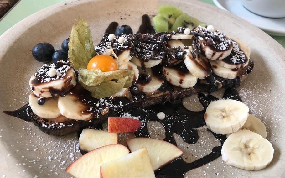 Toast covered with banana, citrus, apple and chocolate drizzle