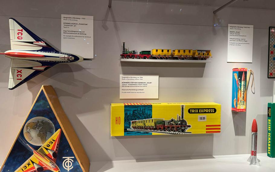 Exhibit at the Nuremberg Toy Museum: A collection of classic toys featuring a colorful rocket model, a retro airplane, a model train set, and vintage packaging. This display captures the charm of mid-20th-century design and showcases the creativity and imagination of toy-making from the era.