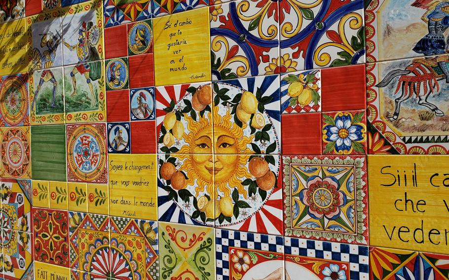 Artistic tile wall featuring a sun, Italian words and flowery patterns