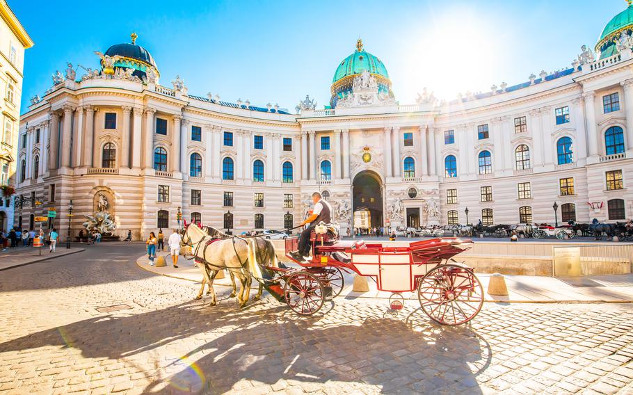 Hofburg Palace and horse carriage on sunny Wien street in Vienna Austria
