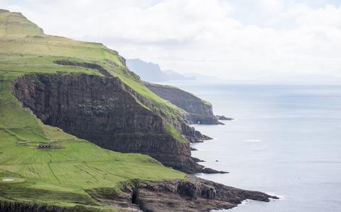 Photo Of Landscape on the Faroe Islands with cliffs blue ocean and green grass