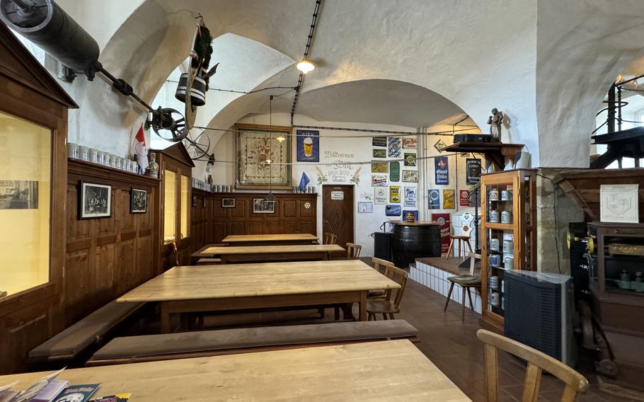 an inviting entrance to a museum with long tables and chairs. 