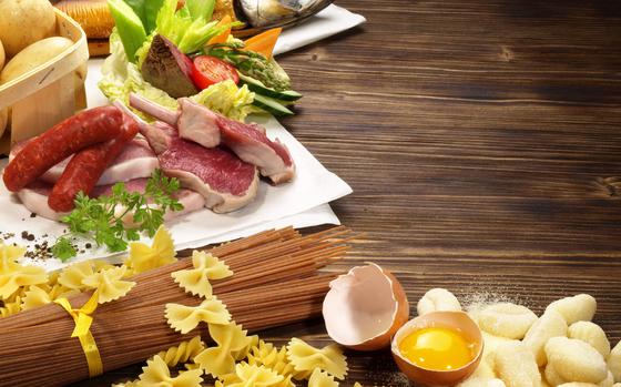 colorful picture of bowtie pastas, egg, gnochi, and fresh meat on a wodden table