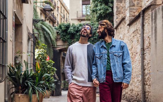 Photo Of male couple walking happy holding hands