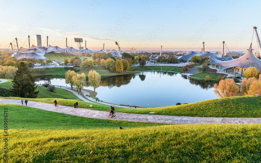 A landscape with a beautiful blue lake and rolling hills with a white stadium